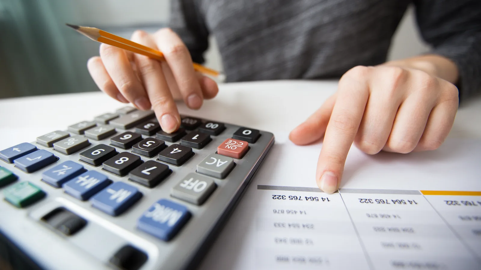 Contador conferindo números com uma calculadora sobre a mesa
